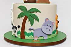 there is a cake with animals on it and palm trees in the backgroud