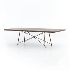 a wooden table sitting on top of a white floor next to a metal frame base