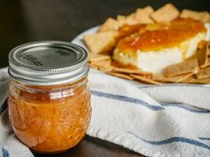 a glass jar filled with food sitting on top of a table next to some chips