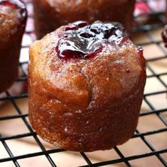 muffins cooling on a wire rack with blueberries in the middle and jam