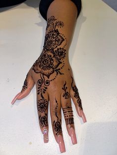 a woman's hand with hennap on it and flowers painted on the palm