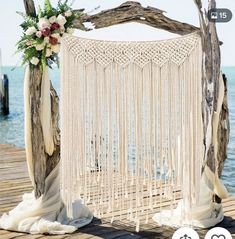 an outdoor wedding ceremony setup with white macrame and flowers on the altar area