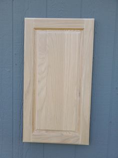 a close up of a wooden frame on a wall with a blue paint color behind it