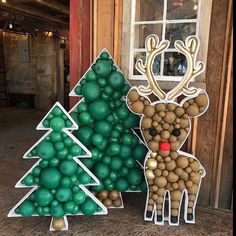 two cardboard christmas trees with balls in the shape of deer and tree on each side