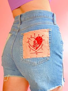 the back of a woman's jean shorts with an image of a heart on it