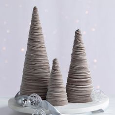 two grey christmas trees sitting on top of a white plate