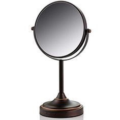 a round mirror sitting on top of a metal stand