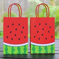 two paper bags with watermelon designs on them sitting on top of a table