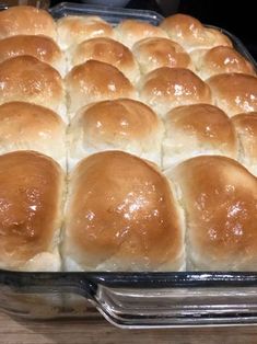 a baking pan filled with rolls sitting on top of a wooden table