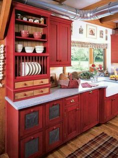 a kitchen with red cabinets and white counter tops