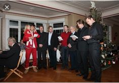 a group of people standing in front of a christmas tree