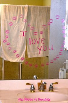 a bathroom sink with two towels hanging on the towel rack above it and an i love you sign