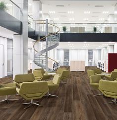 an office with chairs, desks and spiral staircase in the middle of the room