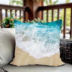 a pillow sitting on top of a couch next to a wicker basket