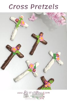 the cross is made out of chocolate and decorated with pink flowers on it's sides