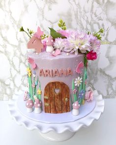 a cake decorated with flowers and the name ariana on it is sitting on a plate