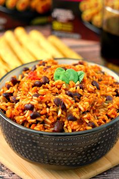 a bowl filled with rice and beans on top of a wooden cutting board