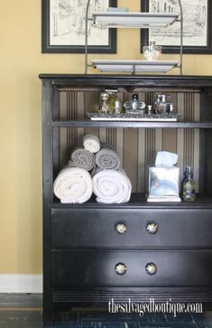 towels are stacked on top of a dresser