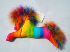 a stuffed toy horse with multicolored fur on it's tail