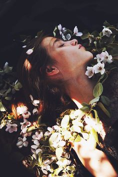 black and white photograph of a woman with flowers in her hair looking up into the sky