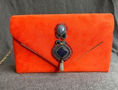 Handbag with orange soutache appliqué. Clutch in the shape of an envelope with a metal chain to which I have incorporated an embroidered applique using the Soutache embroidery technique. The wall light has natural stones, glass and Delica Miyuki beads. Each applique is unique, custom made. If you are interested in any of my items, do not hesitate to write to me because I can make them completely personalized for you. Orange Evening Shoulder Bag With Detachable Strap, Orange Evening Bag With Chain Strap, Chic Orange Clutch, Handmade Orange Clutch Bag, Soutache Embroidery, Orange Handbag, Luxury Orange Bag With Gold-tone Hardware, Party Clutch, Because I Can