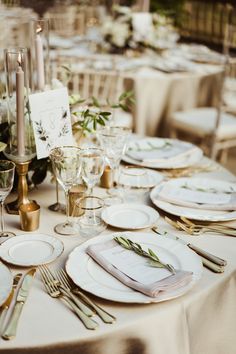 a table set up with place settings and flowers