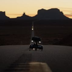 a car driving down the road at sunset