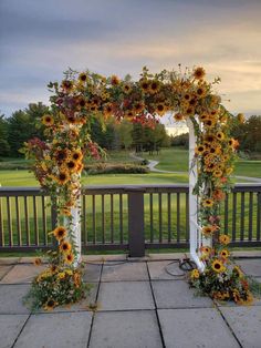 an arch decorated with sunflowers and greenery