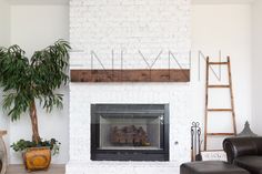 a white brick fireplace with a sign above it that says, place art work here