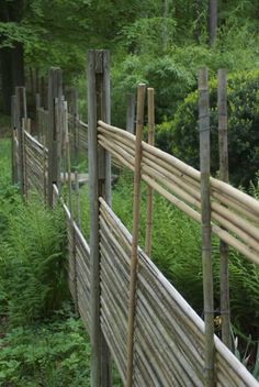 a wooden fence surrounded by tall grass and trees