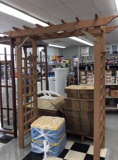 the inside of a store with boxes and crates on the checkerboard floor in front of it