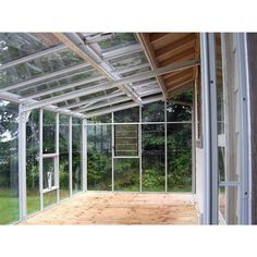 the inside of a glass house with wood flooring