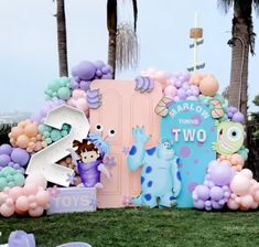 an outdoor birthday party with balloons and decorations on the lawn, including two characters from monsters