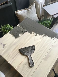 a paintbrush sitting on top of a wooden table next to pillows and other furniture