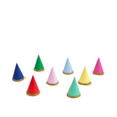 several different colored cones sitting in the middle of a white background with gold rimmed bases