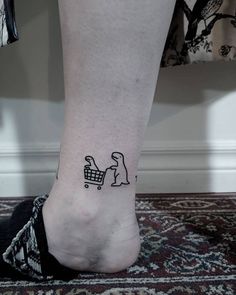 a person's foot with a small tattoo of a dog pushing a shopping cart