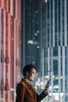 a man standing outside looking at his cell phone