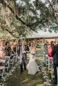 a bride and groom walking down the aisle at their outdoor wedding in charleston, sc