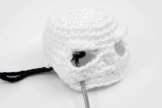 a white crocheted hat with a black handle