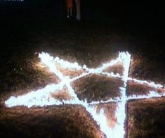 a person standing on top of a hill next to a cross