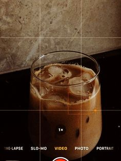 a close up of a drink in a glass on a table with squares around it