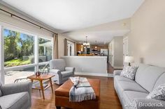 a living room filled with furniture and windows