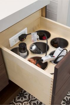 an open drawer with hair dryers and combs in it