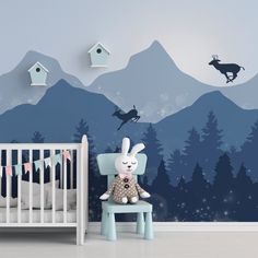 a baby's room with mountains and deer wallpaper