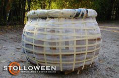 a large basket sitting on top of a dirt field