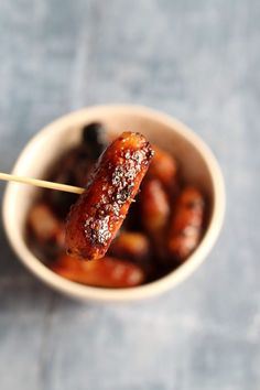 a small bowl filled with food on top of a wooden skewered toothpick