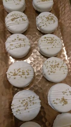 white cookies with gold sprinkles are on a tray, ready to be eaten