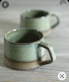 two green cups sitting on top of a wooden table