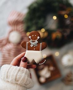 a person holding a gingerbread man ornament in their hand