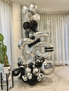 the balloon sculpture is made up of silver and black balloons